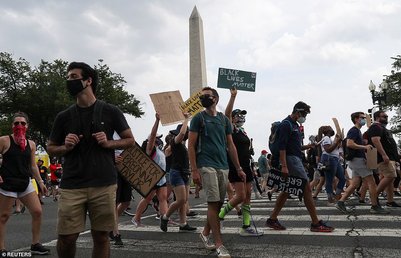 Người biểu tình đi bộ trước Đài tưởng niệm Washington gần Nhà Trắng. Ảnh:Reuters.
