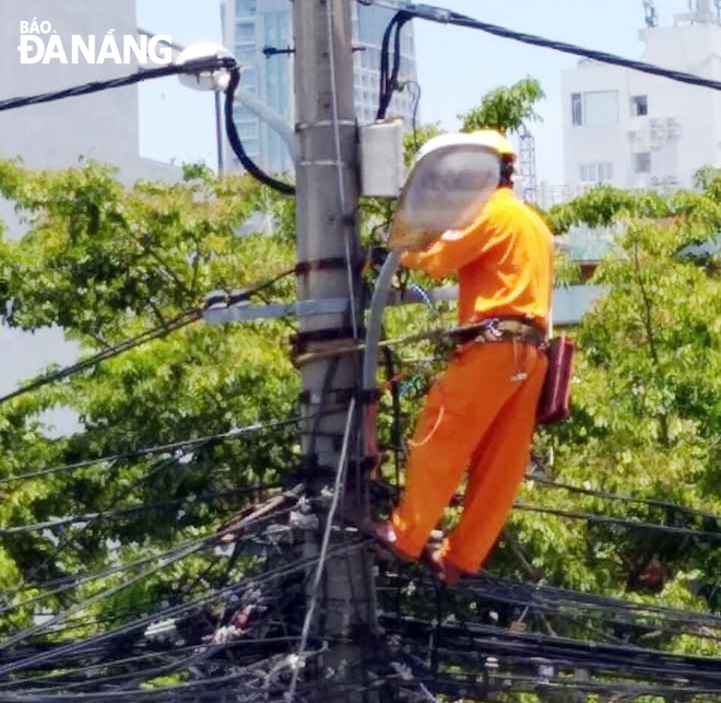 Nhân viên Điện lực Sơn Trà phơi mình giữa nắng để sửa chữa sự cố điện xảy ra hôm 9-6 tại đường Nguyễn Trung Trực. Ảnh từ Facebook nhân vật