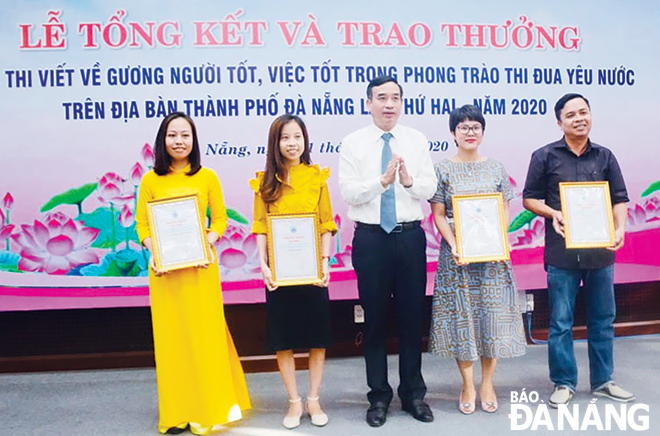 Phó Chủ tịch UBND thành phố Lê Trung Chinh (giữa) trao giải tại Cuộc thi viết về gương người tốt, việc tốt trong phong trào thi đua yêu nước trên địa bàn thành phố năm 2020.  Ảnh: HẢI ÂU