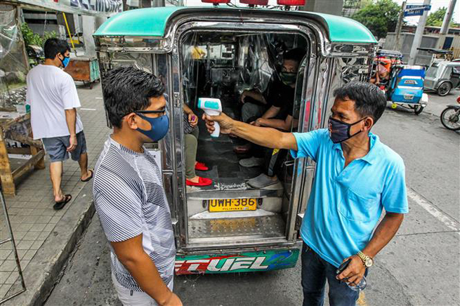  Tài xế xe Jeepney kiểm tra thân nhiệt cho hành khách tại Manila, Philippines, ngày 3-7-2020, trong bối cảnh dịch Covid-19 lan rộng. Ảnh: THX/ TTXVN
