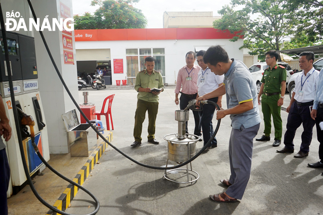 Chi cục Tiêu chuẩn Đo lường Chất lượng Đà Nẵng tiến hành đo lường tại cửa hàng xăng dầu Ngọc Khánh (quận Hải Châu). Ảnh: TRẦN NHIÊN