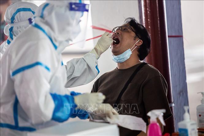 Nhân viên y tế lấy mẫu dịch xét nghiệm COVID-19 cho người dân tại Hong Kong, Trung Quốc ngày 19/7. Ảnh: AFP/TTXVN