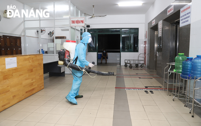 Phun hóa chất khử trùng bên trong Bệnh viện Đà Nẵng. Ảnh: PHAN CHUNG	