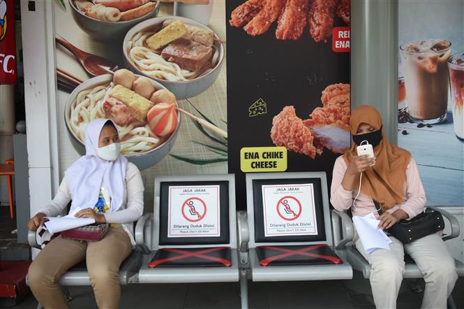 Người dân đeo khẩu trang và thực hiện giãn cách xã hội phòng lây nhiễm COVID-19 tại Jakarta, Indonesia, ngày 27/7/2020. Ảnh: THX/TTXVN