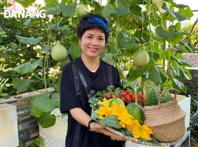Chị Trần Thị Hòa với nguồn rau quả sạch tự trồng tại sân thượng. Ảnh: T.Y
