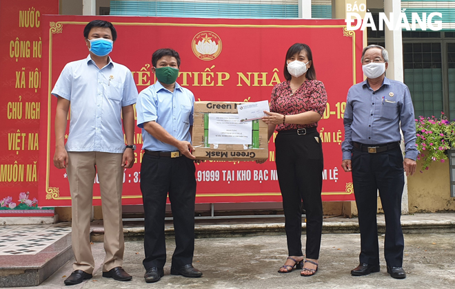 Ban điều hành Chương trình Ly cà phê Yêu thương (bìa trái) trao tặng tiền mặt và khẩu trang y tế đến Ủy ban MTTQ Việt Nam quận Cẩm Lệ. 		           Ảnh: ĐẶNG NỞ