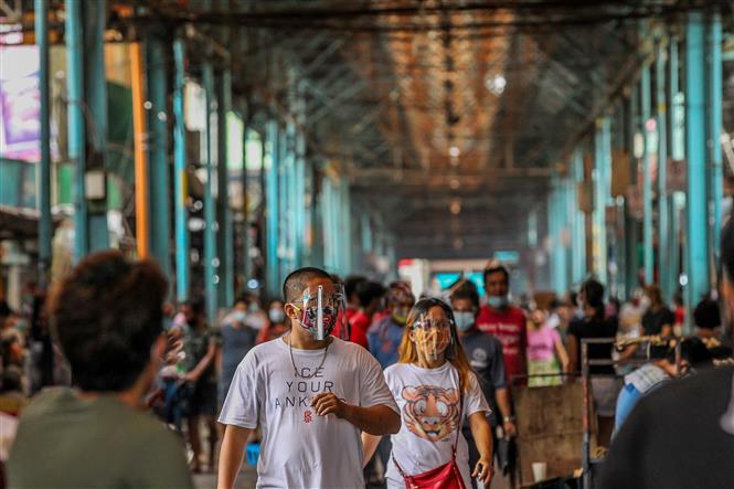 Người dân đeo khẩu trang và tấm chắn nhằm ngăn chặn sự lây lan của dịch COVID-19 khi mua sắm tại một khu chợ ở Manila, Philippines ngày 16/8/2020. Ảnh: THX/TTXVN