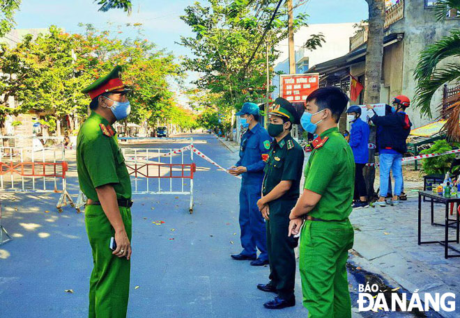 Phó Trưởng Công an quận Ngũ Hành Sơn Kiều Văn Vương (bìa trái) thăm  động viên cán bộ, chiến sĩ các lực lượng tại chốt kiểm dịch. Ảnh: Đ.S