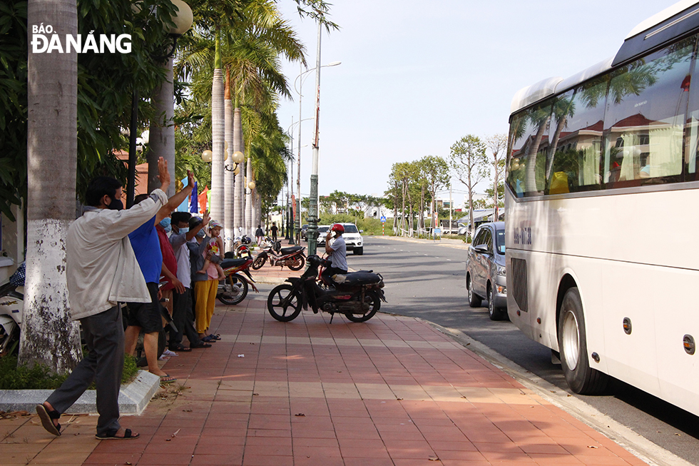 Chiều 7-9, tỉnh Bắc Ninh đón 20 công dân từ Đà Nẵng về địa phương. Trong ảnh: Người thân của các công dân tỉnh Bắc Ninh vẫy tay chào tạm biệt nhau trước khi xe lăn bánh.