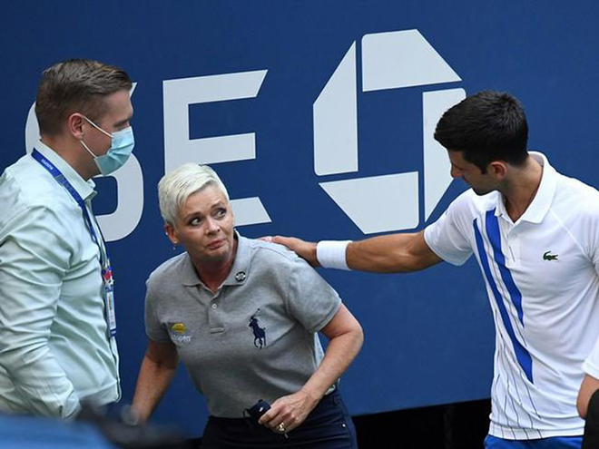 Novak Djokovic (bìa phải) xin lỗi nữ trọng tài biên sau khi vô tình đánh trái banh ra sau trúng bà. Ảnh: Getty Images