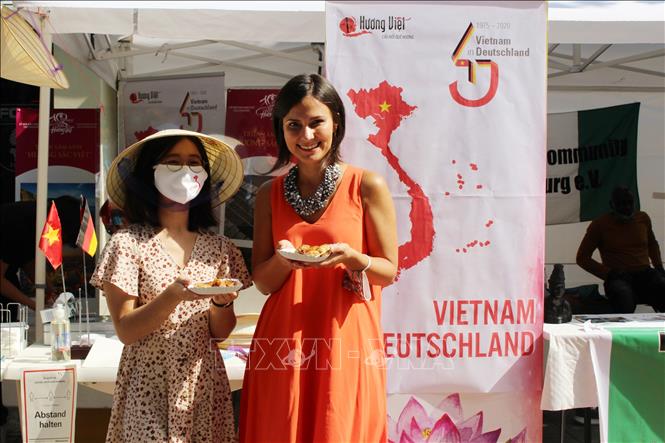  Chú thích ảnh Phó Thị trưởng Thành phố Augsburg, bà Martina Wild (áo dài cam), ấn tượng với ẩm thực của Việt Nam. Ảnh: TTXVN phát