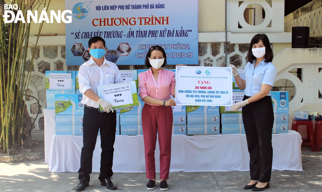 Chủ tịch Hội LHPN thành phố Đà Nẵng Hoàng Thị Thu Hương (bìa phải) và nhà tài trợ trao tặng sữa cho Hội LHPN các quận, huyện hỗ trợ công tác phòng, chống Covid-19. Ảnh: L.P	