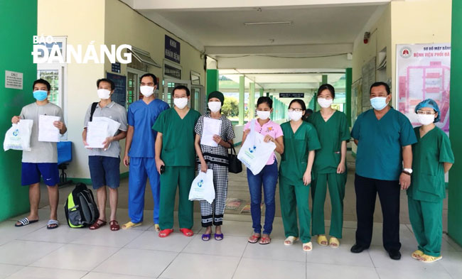 Nhân viên y tế Bệnh viện Phổi Đà Nẵng làm thủ tục xuất viện và chia tay 4 bệnh nhân được điều trị khỏi Covid-19 ngày 15-9. Ảnh: H.T.