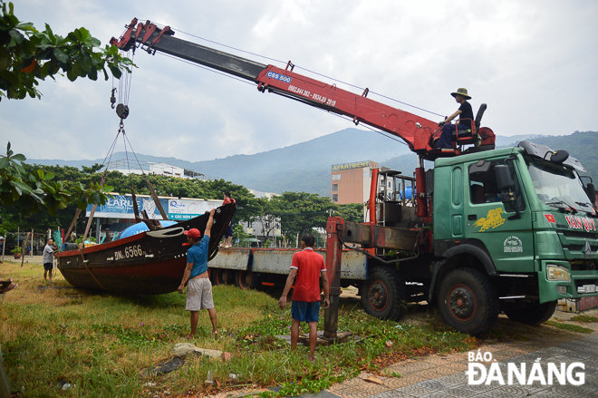 Ngư dân quận Sơn Trà thuê xe cẩu để đưa thuyền vào nơi tránh trú an toàn. Ảnh: XUÂN SƠN