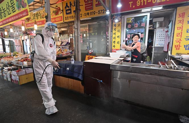 Nhân viên y tế phun thuốc khử trùng nhằm ngăn dịch COVID-19 lây lan tại khu chợ ở Seoul ngày 18/8/2020. Ảnh: AFP/TTXVN