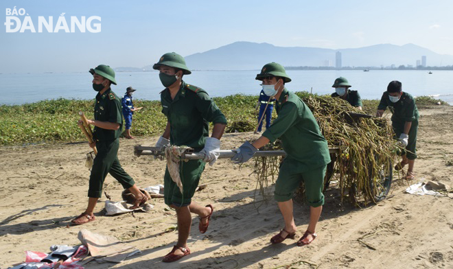 Cán bộ, chiến sĩ Đồn Biên phòng Phú Lộc tích cực thu gom rác tấp vào bãi biển. Ảnh: HOÀNG HIỆP
