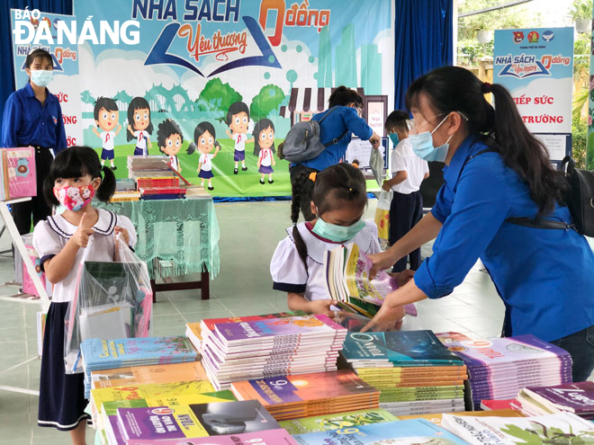 Học sinh tại Trường tiểu học Lâm Quang Thự nhận những bộ sách ý nghĩa vào đầu năm học mới tại chương trình “Nhà sách yêu thương 0 đồng” do Hội đồng đội Đà Nẵng tổ chức. Ảnh: XUÂN ĐÔNG