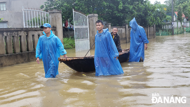 Local residents using boats to get through a massive volume of floodwaters in Hoa Phong Commune