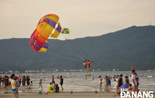 Tourists experiencing parasailing on a beach in Da Nang