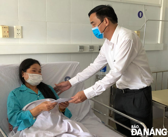 Vice Chairman Chinh giving spiritual encouragement and cash gift to a victim being treated at the Da Nang General Hospital