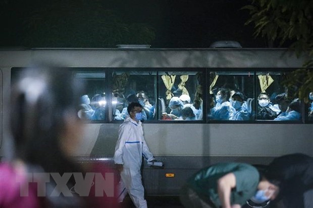 A coach taking newly arriving passengers to quarantine facilities (Photo: VNA)