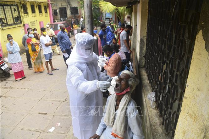 Nhân viên y tế lấy mẫu dịch xét nghiệm COVID-19 cho người dân tại Mumbai, Ấn Độ ngày 12/10. Ảnh: AFP/TTXVN