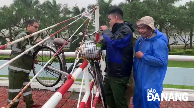 CAP An Hải Bắc cứu 1 người đàn ông đi xe đạp băng qua cầu Sông Hàn, bị ngã, bu bám trên thành cầu. Ảnh: XUÂN SƠN