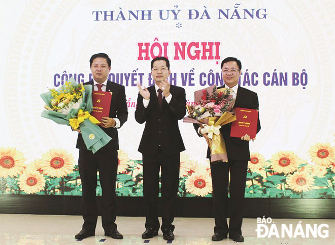 Bí thư Thành ủy Nguyễn Văn Quảng (giữa) trao quyết định và tặng hoa chúc mừng đồng chí Lương Nguyễn Minh Triết (bên trái) và đồng chí Vũ Quang Hùng (bên phải). Ảnh: TRỌNG HÙNG