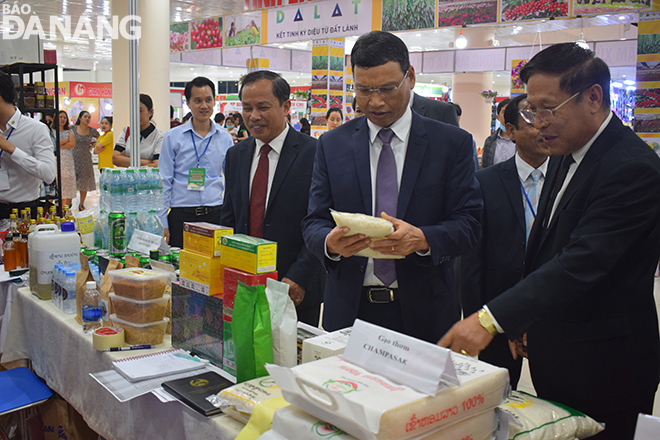 Phó Chủ tịch UBND Hồ Kỳ Minh (thứ hai từ phải sang) thăm gian hàng trưng bày tại EWEC 2020 của doanh nghiệp đến từ nước bạn Lào. Ảnh: KHÁNH HÒA