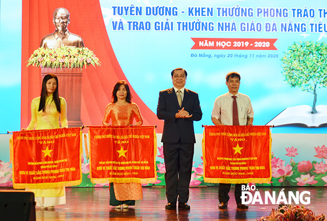 Thừa ủy quyền của Thủ tướng Chính phủ, Chủ tịch UBND thành phố Huỳnh Đức Thơ trao Cờ thi đua của Chính phủ cho 3 tập thể. Ảnh: NGỌC PHÚ