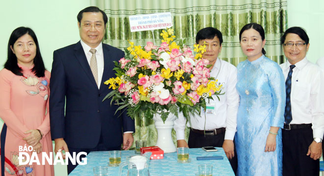 Chủ tịch UBND thành phố Đà Nẵng Huỳnh Đức Thơ (thứ 2, trái qua) tặng hoa chúc mừng Trường THCS Nguyễn Bỉnh Khiêm. Ảnh THANH TÌNH