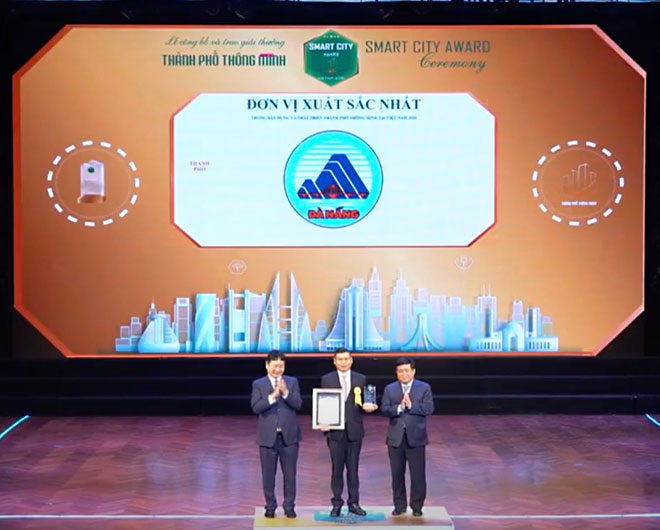 On behalf of the Da Nang authorities and people, municipal People's Committee Vice Chairman Ho Ky Minh (middle) receiving the ‘Viet Nam Smart City Award 2020 at the Tuesday awards ceremony in Ha Noi