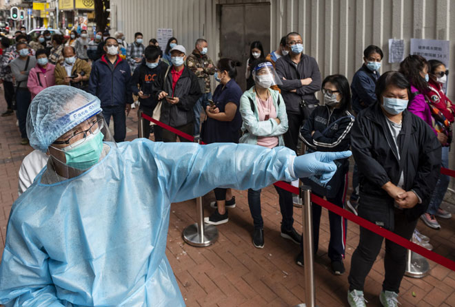 Du khách xếp hàng bên ngoài một Trung tâm xét nghiệm cộng đồng ở Hong Kong (Trung Quốc) chờ xét nghiệm SARS-CoV-2 ngày 30-11. Ảnh: Anadolu Agency/Getty Images	