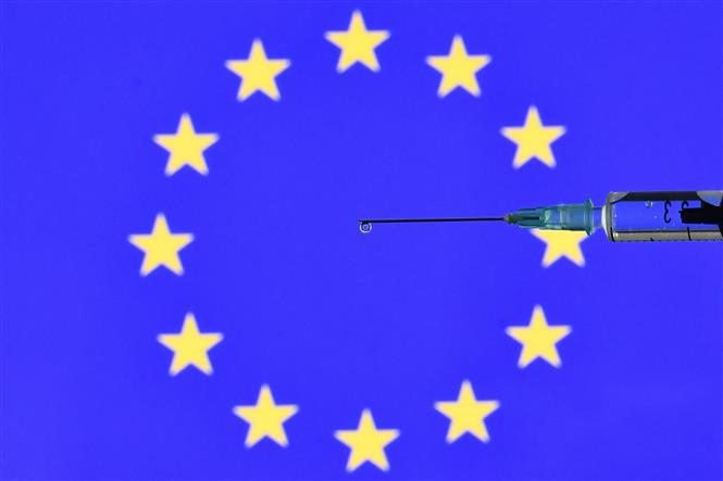 Biểu tượng tiêm phòng vaccine Covid-19 trên nền cờ Liên minh châu Âu, ngày 17-11-2020. Ảnh: AFP/TTXVN