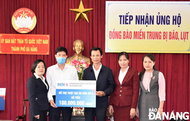 Phó Chủ tịch Ủy ban MTTQ Việt Nam thành phố Lê Văn Minh (giữa) tiếp nhận kinh phí hỗ trợ từ doanh nghiệp. Ảnh: H.H