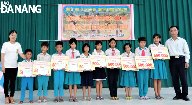 Ông Phạm Đình Văn (bìa phải) trao quà cho các em học sinh huyện Nam Giang, tỉnh Quảng Nam. Ảnh:  HUY HOÀNG	
