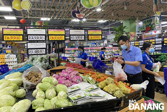 Nhân viên siêu thị Co.opmart Sơn Trà chuẩn bị combo hàng hóa cho người dân. Ảnh: KHÁNH HÒA