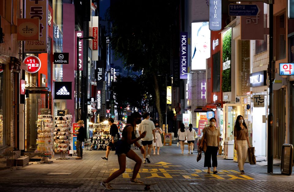 Người phụ nữ trượt ván trên phố mua sắm ở Seoul, Hàn Quốc hôm 12/7. Ảnh: Reuters