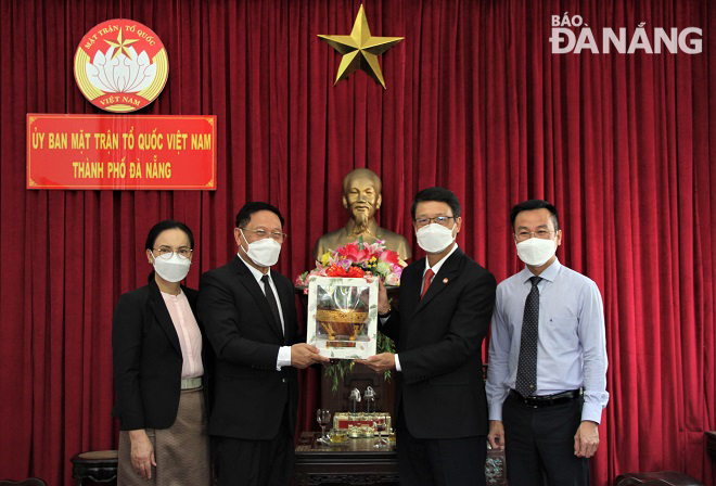 Chủ tịch Ủy ban MTTQ Việt Nam thành phố Ngô Xuân Thắng () tặng quà lưu niệm cho Tổng Lãnh sự Lào tại Đà Nẵng Viengxay Phommachanh. Ảnh: L.P