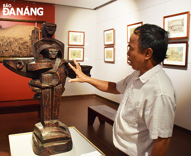 Họa sĩ Nguyễn Trung Kỳ giới thiệu một bức tượng điêu khắc về đề tài chiến tranh được trưng bày tại Bảo tàng Mỹ thuật Đà Nẵng. Ảnh: Đ.H.L