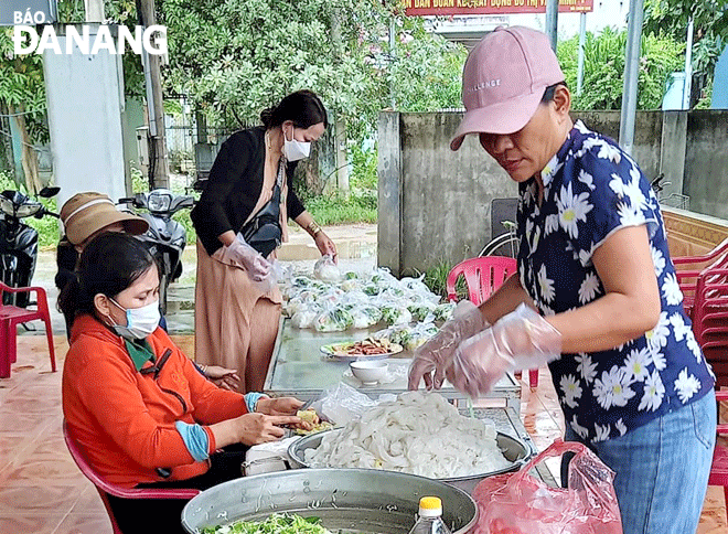 Thành viên nhóm “Thiện nguyện phụ nữ Khánh Sơn” chuẩn bị suất ăn tặng cho người dân khó khăn. Ảnh: L.P