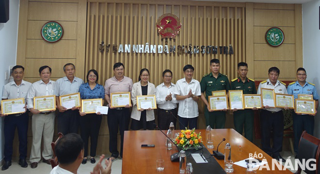 Bí thư Quận ủy và Chủ tịch UBND quận Sơn Trà tuyên dương, trao giấy khen cho các tập thể có thành tích xuất sắc trong công tác khắc phục môi trường sau bão. Ảnh: HOÀNG HIỆP