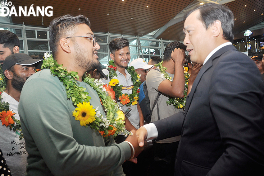 Tổng cục trưởng Tổng cục Du lịch Nguyễn Trùng Khánh (phải) tặng hoa chúc mừng những hành khách trên chuyến bay đầu tiên từ Đà Nẵng đến Ấn Độ. Ảnh: THU HÀ