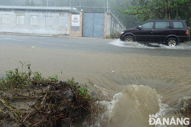 Mưa to tại khu vực suối Đá (quận Sơn Trà) với lượng mưa đo được từ 4-7 giờ sáng 25-10 là 59,6mm làm nước từ núi chawyr băng qua đường Lê Văn Lương. Ảnh: HOÀNG HIỆP