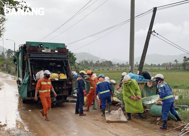 Công nhân thuộc Xí nghiệp Môi trường Hòa Vang tổng dọn, thu gom rác ở xã Hòa Bắc sau lũ lụt lịch sử vừa qua. Ảnh: HOÀNG HIỆP