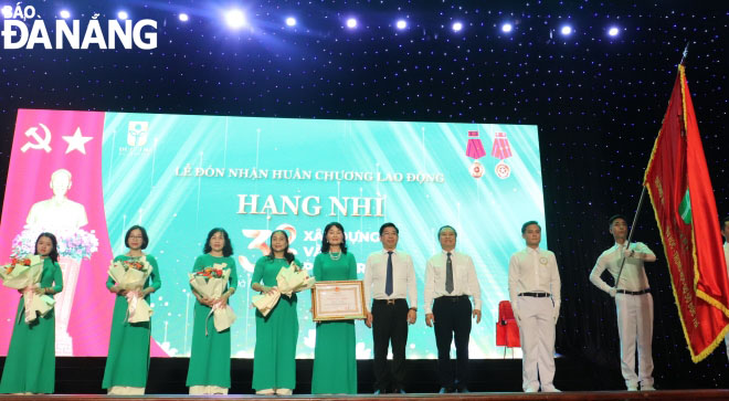 Thừa ủy quyền của Chủ tịch nước, đại diện lãnh đạo quận Hải Châu, Sở Giáo dục và Đào tạo trao tặng Huân chương Lao động Hạng Nhì và hoa cho Trường Mầm non - Tiểu học - THCS Đức Trí. Ảnh: NGỌC HÀ.,