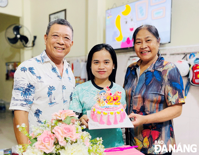 Phonelida Chanthavongsa (center) celebrates her 22nd birthday with the family of Mrs. Tran Thi Nguyen residing in Hoa Khanh Nam Ward, Lien Chieu District. Photo: X.HAU