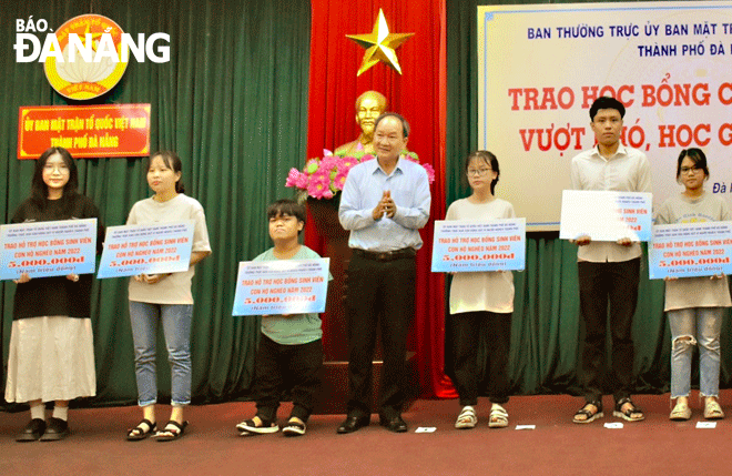 Phó Chủ tịch Ủy ban MTTQ Việt Nam thành phố Dương Đình Liễu (giữa) trao học bổng cho học sinh nghèo vượt khó học giỏi năm 2022. Ảnh: N.QUANG