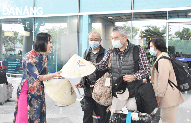 Du khách Hàn Quốc thích thú khi được chào đón và nhận quà tặng tại sân bay quốc tế Đà Nẵng đầu năm mới 2023. Ảnh: THU HÀ	