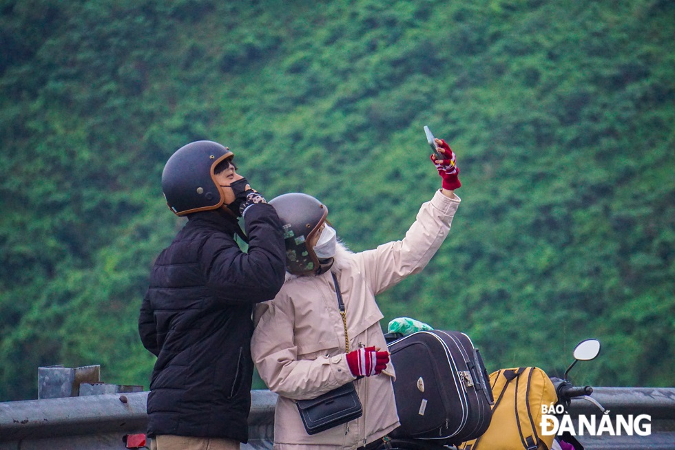 Nhiều bạn trẻ tranh thủ chụp ảnh tại đỉnh đèo Hải Vân với những làn mây sớm.